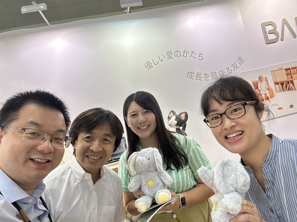 Michael Chen and Japanese visitors holding interactive elephant toys at the 2025 Tokyo Toy Show